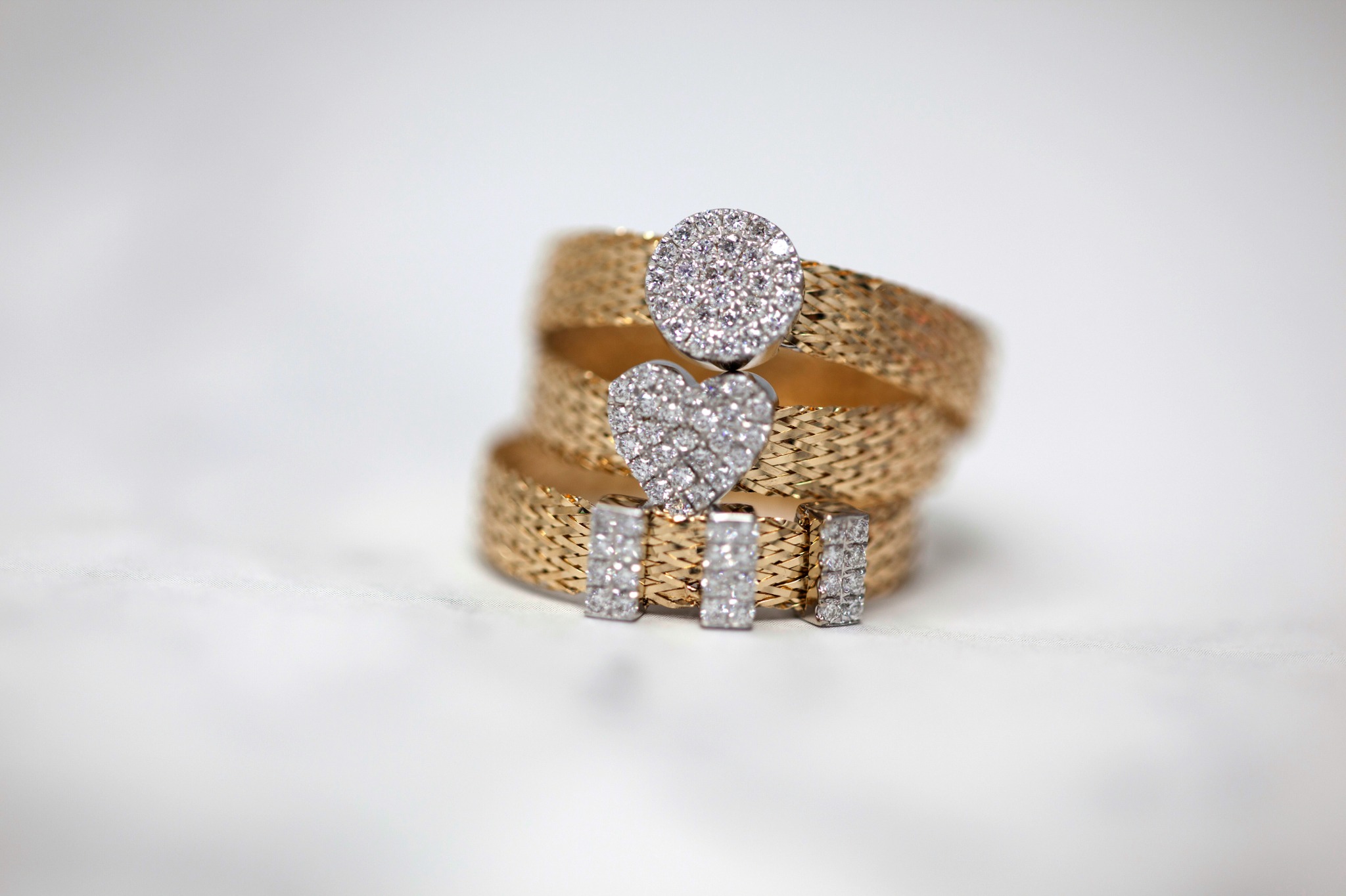 Gold and diamond rings arranged on a light background